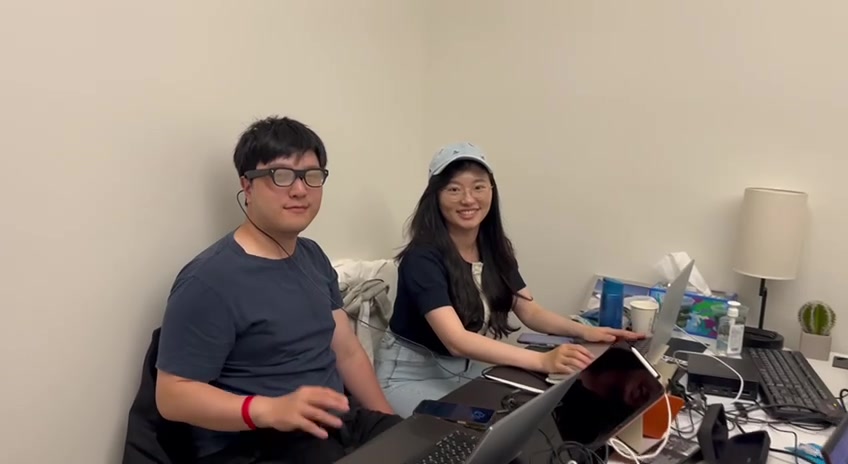 Two members of the MEMO team working together at their desks during the hackathon
